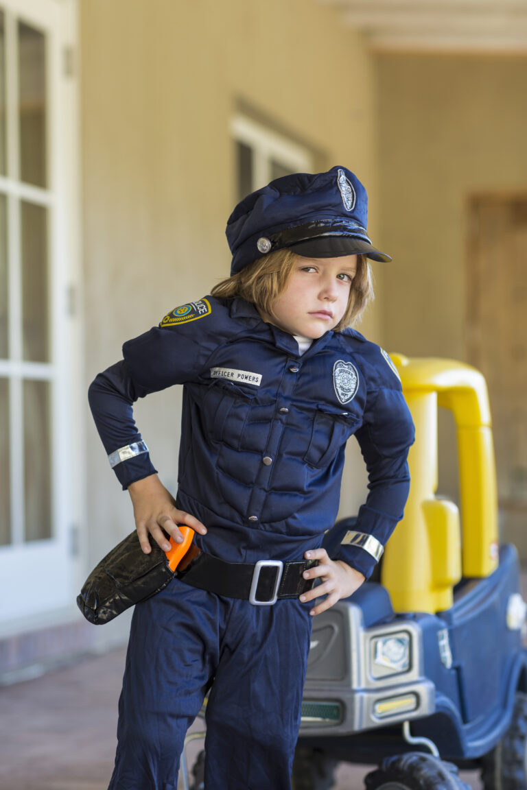 Enfant déguisé en policier jouant dans la ville miniature Youpi Parc City